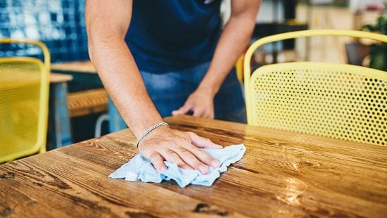 Restaurant staff wiping down a table