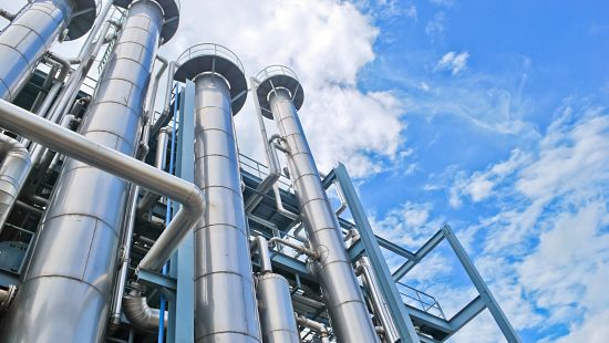 Looking up at chemical plant stacks stock photo